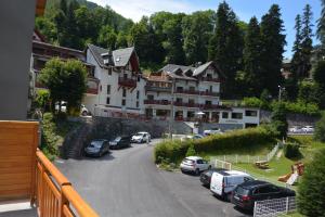 Un gran edificio con coches aparcados en un estacionamiento. en A vous les Trois Vallées, en Brides-les-Bains