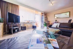 ein Wohnzimmer mit einem Sofa und einem TV in der Unterkunft Zwei 4 Sterne Wohnungen bei Limburg in Mensfelden