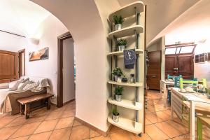 una habitación con cocina y una mesa con plantas en los estantes en B&B Finalex, en Finale Ligure