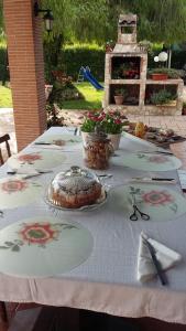 a table with a white table cloth with flowers on it at Casale Del Borgo in Hermada