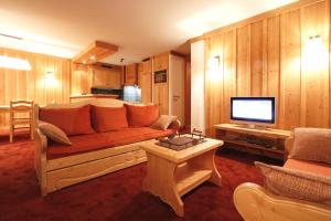 ein Wohnzimmer mit einem Sofa und einem TV in der Unterkunft Vacanceole - Résidence Goléon -Val Ecrins in Les Deux Alpes