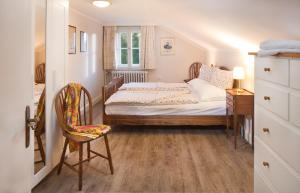 a small bedroom with a bed and a chair at Villa Wilhelmine in Oberperfuss