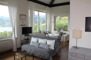 a living room with a couch and some windows at La Maisonette in Miasino