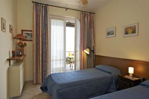 a bedroom with two beds and a large window at Residence Roccolo in Ghiffa