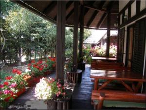 a porch with benches and flowers in a garden at Guest House Alpska Vila in Zlatibor