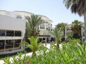 a building with palm trees in front of it at Palmyra Golden Beach - Families and Couples in Monastir