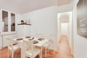 フィレンツェにあるSublime Home Downtown Florenceの白いダイニングルーム(白いテーブルと椅子付)