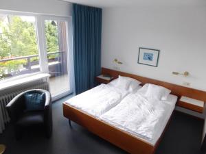 a bedroom with a bed and a chair and a window at Bremer Schlüssel in Braunlage