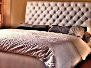 a bedroom with a bed with a tufted headboard at Villino CORTEBOZZINI in Bardolino