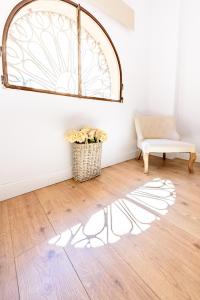 グラナダにあるApartamento Jardín Botánico Iの椅子と窓が備わる客室で、床に影が付いています。