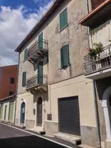 un edificio con persianas verdes y balcones en una calle en My Vintage Home, en Bassano in Teverina