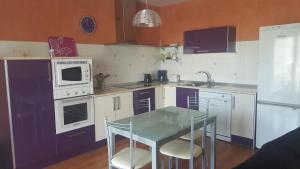 VillamarcielにあるCasa Anaのキッチン(紫と白の電化製品、ガラステーブル付)