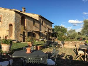 a building with a table and chairs in a yard at La Canonica Di San Michele in Monteriggioni