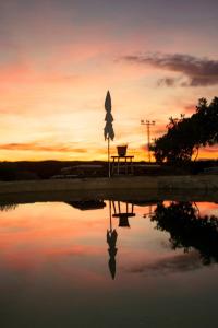 a sunset with a reflection of a table in a pond at Finca El Cerco a 5m de Puy du Fou y 10m a casco antiguo de Toledo in Argés