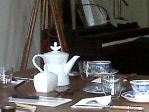 a table with a tea pot and cups and a piano at Les Trois Maillets, Monument Historique in Orléans