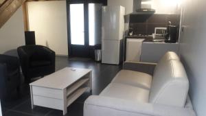 een woonkamer met een witte bank en een tafel bij Ti Fleur aimée à Cilaos in Cilaos