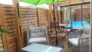 eine Terrasse mit Stühlen, einem Tisch und einem Sonnenschirm in der Unterkunft Ti Fleur aimée à Cilaos in Cilaos
