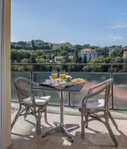 einen Tisch mit 2 Stühlen und Getränke auf dem Balkon in der Unterkunft Hotel Cacciani in Frascati