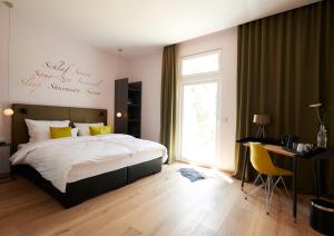 um quarto com uma cama, uma secretária e uma janela em LIONO BoutiqueHotel em Goslar