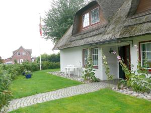 a house with a stone walkway in front of it at Apartment Am Mühlendeich in Vollerwiek