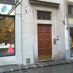 a store front with a brown door in a window at Oche in Florence