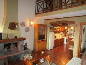 eine Küche und ein Wohnzimmer mit einem Kamin in der Unterkunft Casa Ilhéu - Fajã do Fisher in Feteira