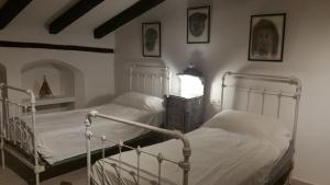 a bedroom with two beds and a table with a lamp at Apartamento en casco antiguo Moratalla in Moratalla