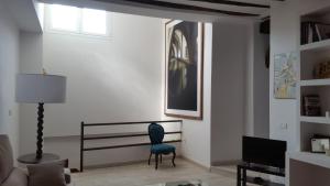 a living room with a blue chair and a television at Apartamento en casco antiguo Moratalla in Moratalla