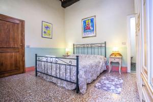 a bedroom with a bed and a table and a door at Casa Quintani in Cortona