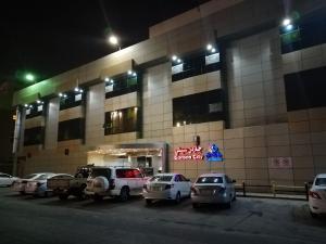 um parque de estacionamento em frente a um edifício à noite em Garden City 2 em Riade