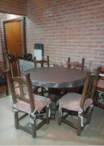 a table with four chairs and a brick wall at Cabaña San Pablo in San Salvador de Jujuy