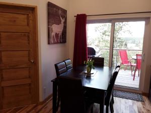 a dining room with a table and chairs and a balcony at Résidence touristique Lodge des Bois in Saint-Félix-d'Otis