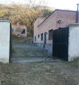 una entrada a un edificio de ladrillo con una puerta negra en Cabaña San Pablo en San Salvador de Jujuy