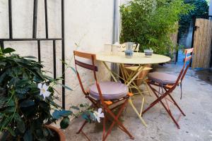 uma mesa com duas cadeiras e uma mesa com copos em Gîte la Chèvre d'Or em Aniane
