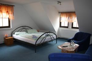 a bedroom with a bed and a couch and a table at Gasthaus & Hotel Zur Linde in Hermsdorf