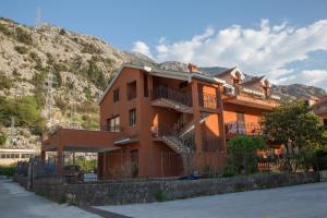 um edifício com varandas e escadas em frente a uma montanha em Apartment Atina em Kotor