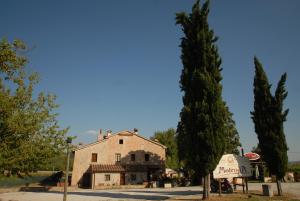 an old stone building with a tree and a sign at Molenda B&B in Città di Castello