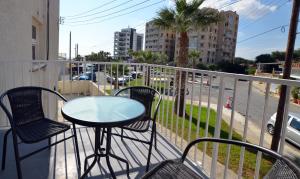 un balcone con tavolo, sedie e una strada di Blu Studio on the Sea a Larnaka