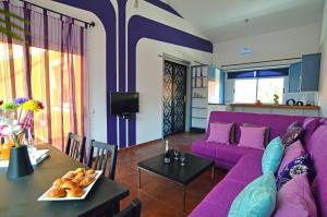 コラレホにあるKalmahouseの紫色のソファとテーブル付きのリビングルーム