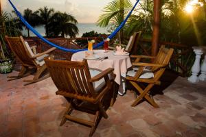 a table and chairs on a patio with the ocean at Hotel La Joya Isla Mujeres in Isla Mujeres