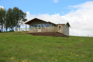 a small house on top of a grassy hill at Eyvindartunga farm cottage in Laugarvatn