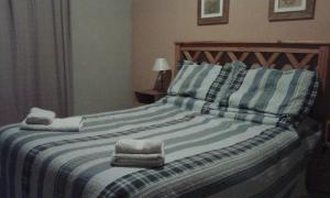 a bedroom with a bed with towels on it at Cabañas Los Aromos in Tandil