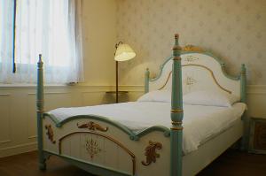 a bedroom with a canopy bed with a lamp at Yo Muma Homestay in T'ien-wei