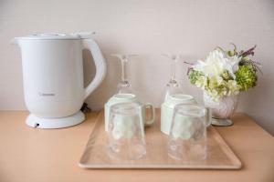 a counter with a blender and glasses and a vase with flowers at Number 6 Nijo in Kyoto