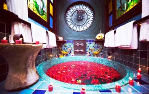 a bathroom with a large tub filled with redbles and a clock at Hotel Tugu Bali, Canggu in Canggu +68 photos