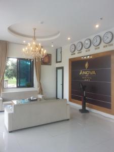 sala de estar con sofá y pared con reloj en Anova Airport Hotel, en Noi Bai