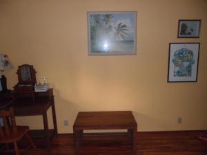 a room with a table and a desk and a picture on the wall at A Beautiful Edge of the World Bed & Breakfast in Captain Cook