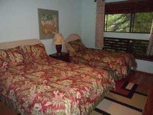 1 dormitorio con cama, lámpara y ventana en A Beautiful Edge of the World Bed & Breakfast, en Captain Cook