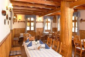 a dining room with wooden tables and chairs at Tapolca Fogadó in Miskolctapolca