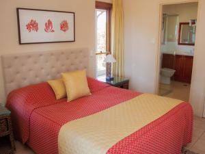 a bedroom with a large bed with a red and white blanket at Berenbell Vineyard Retreat in Pokolbin